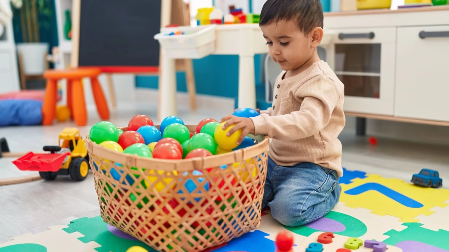 adorable-hispanic-toddler-playing-with-balls-twinnienursery.webp