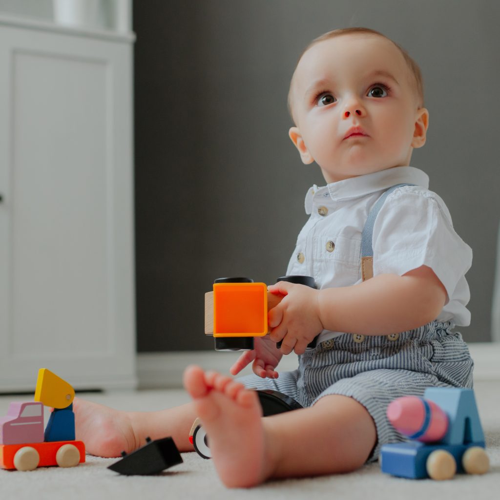 baby-sitting-floor-with-toys-suprised