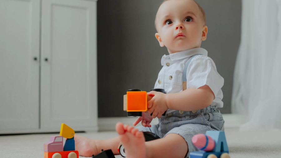 baby-sitting-floor-with-toys-suprised.webp