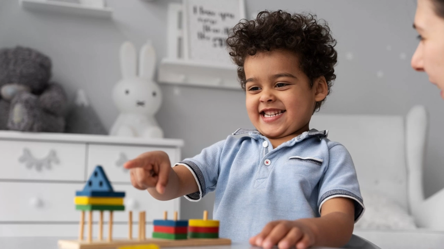 Baby boy enjoying game at the best day care school twinnienursery school uk