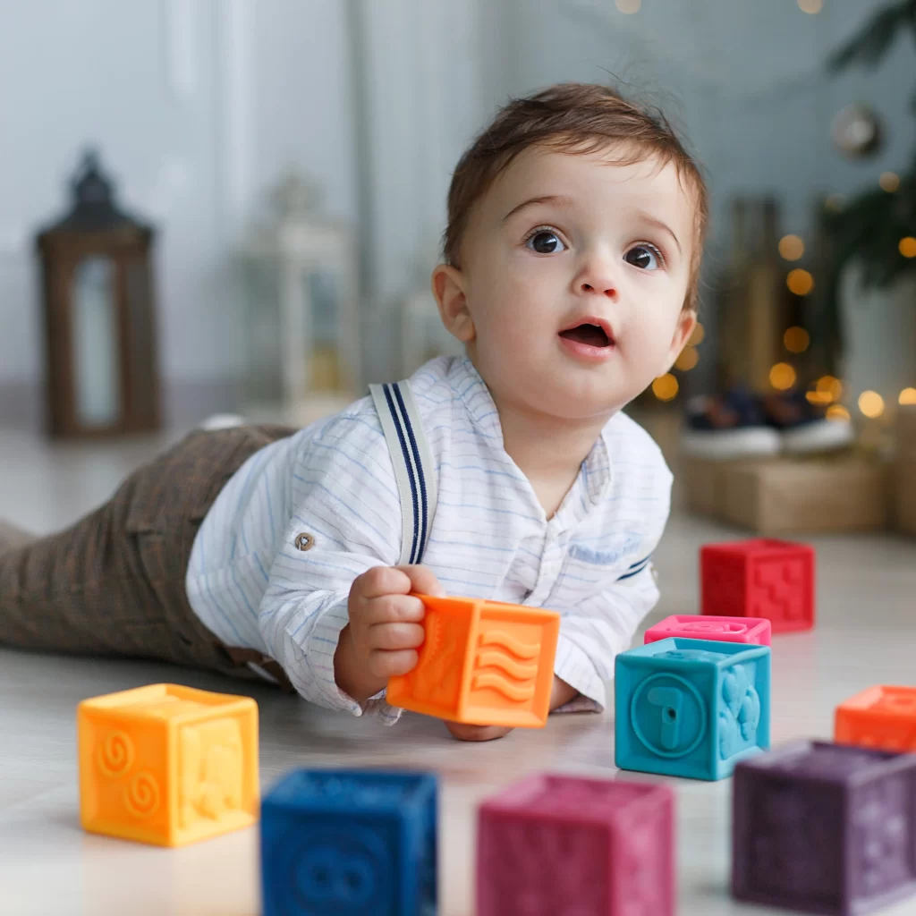 Cute baby with toys at twinnienursery school