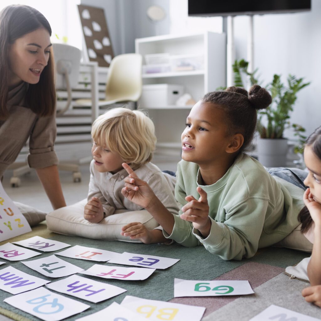 Woman teaches children words in twinnienursery school uk